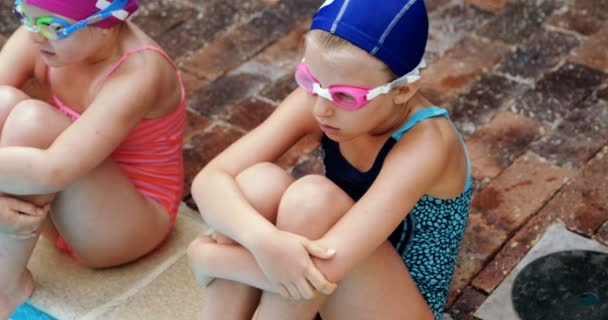 Niedliche kleine Kinder sitzen in der Nähe von Schwimmbad — Stockvideo