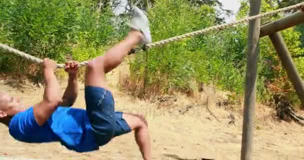 Man beoefenen touwklimmen tijdens hindernissenparcours — Stockvideo