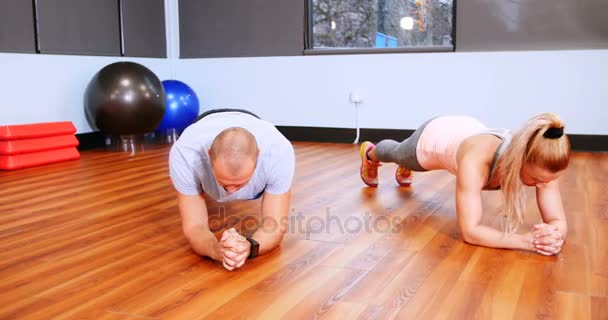 Homem e mulher realizando exercício de prancha — Vídeo de Stock