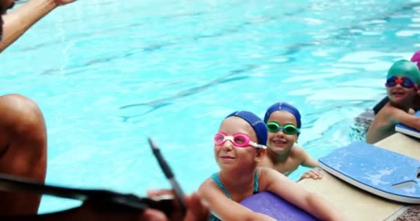 Entrenador dando clases de natación a sus estudiantes — Vídeo de stock