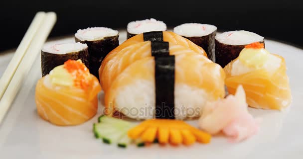 Суши подаются на тарелке с палочками для еды — стоковое видео