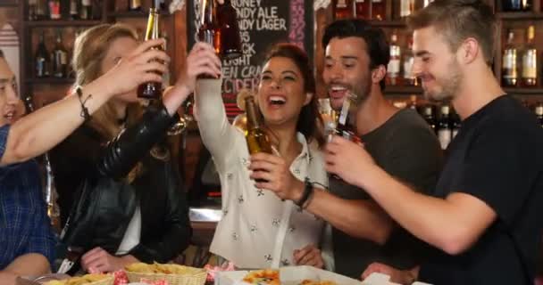 Группа друзей, общающихся во время тоста за бутылки пива — стоковое видео
