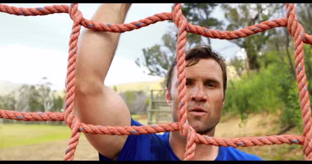 Homem escalando uma rede durante o curso de obstáculo — Vídeo de Stock