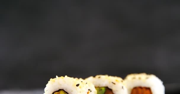 Uramaki sushi serveras på natursten skiffer — Stockvideo