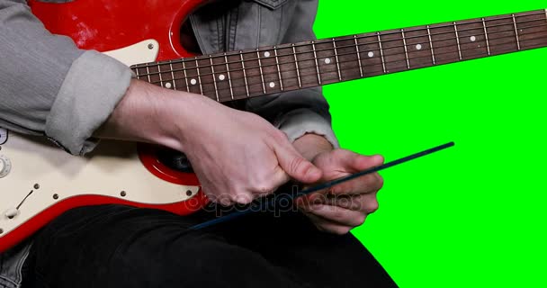 Человек держит цифровой планшет во время игры на гитаре — стоковое видео