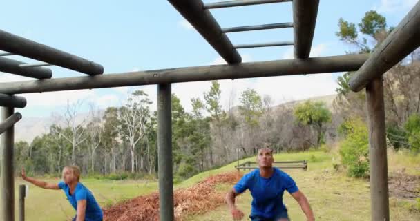 Man en vrouw klimmen monkey bars — Stockvideo