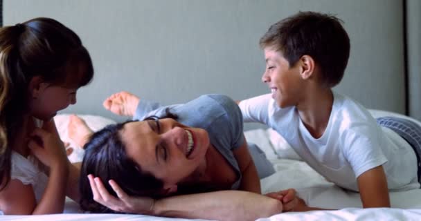 Мама веселилась со своими детьми в постели — стоковое видео