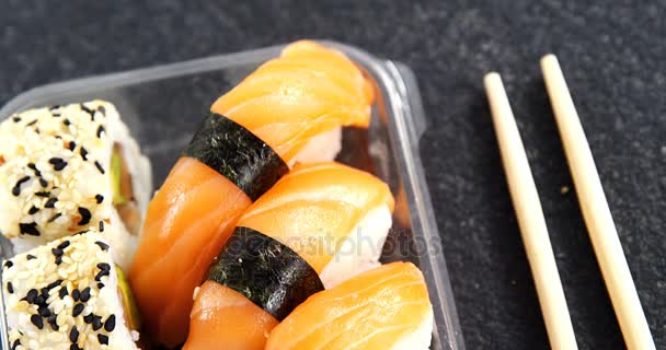 Plastový zásobník na různých sushi rohlíky s lososem — Stock video