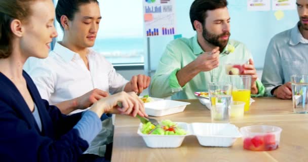 Ejecutivos de negocios sonrientes comiendo en la oficina — Vídeos de Stock