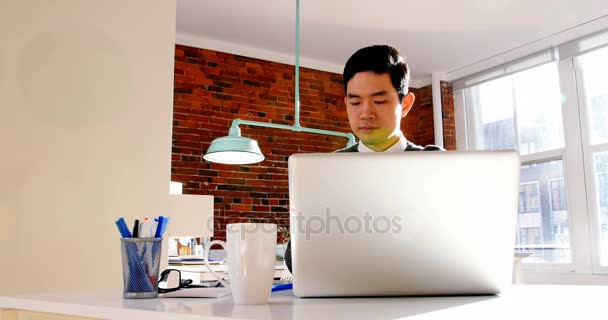 Executivo masculino falando no telefone celular enquanto usando laptop — Vídeo de Stock