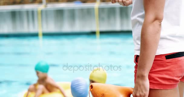 Treinador de pé com apito perto da piscina — Vídeo de Stock