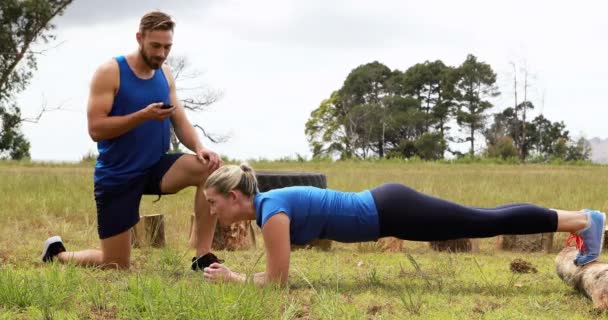 Mulher treinadora durante o curso de obstáculos — Vídeo de Stock