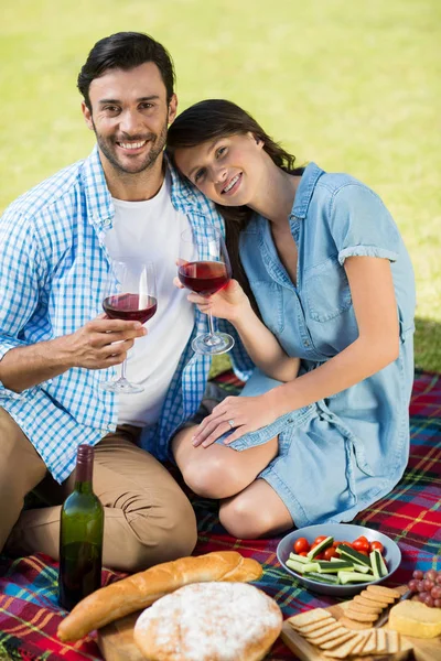 Pareja sonriente sosteniendo copas de vino — Foto de Stock