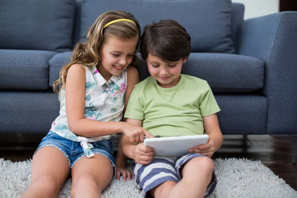 Broers en zussen met behulp van digitale tablet in woonkamer — Stockfoto