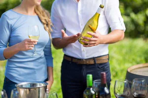 Parte média do homem mostrando garrafa de vinho — Fotografia de Stock