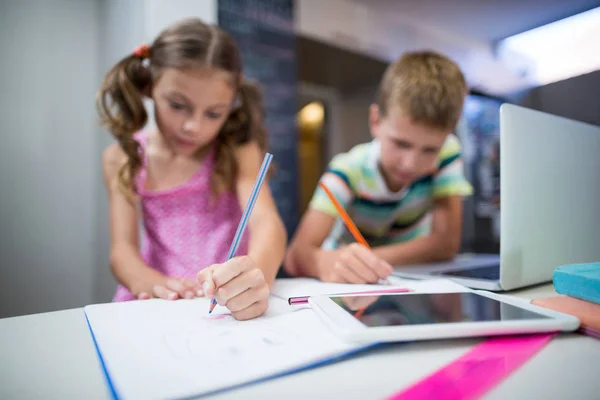 Broers en zussen doen hun huiswerk in de keuken — Stockfoto