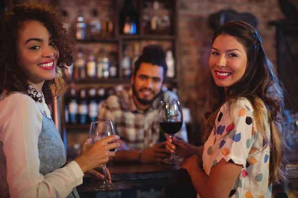 Young women having red wine at counter — Stock Photo, Image