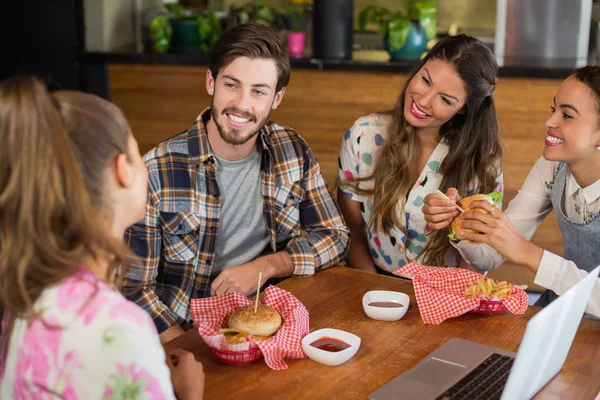 Amis ayant un hamburger au restaurant — Photo