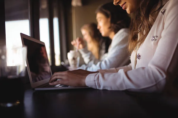 Vrouw met laptop in restaurant — Stockfoto