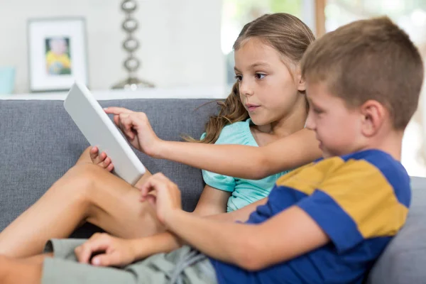 Geschwister nutzen digitales Tablet im Wohnzimmer — Stockfoto