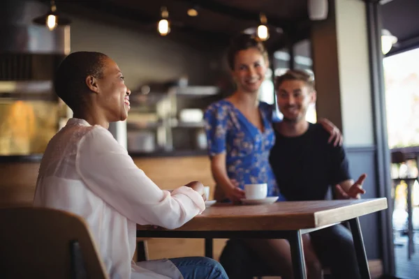 Friend interacting with couple while having coffee — Stock Photo, Image
