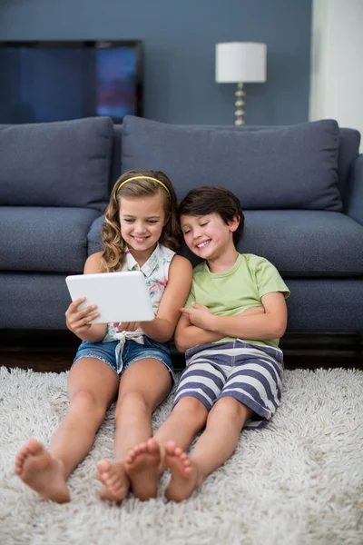Syskon med digital tablett i vardagsrum — Stockfoto