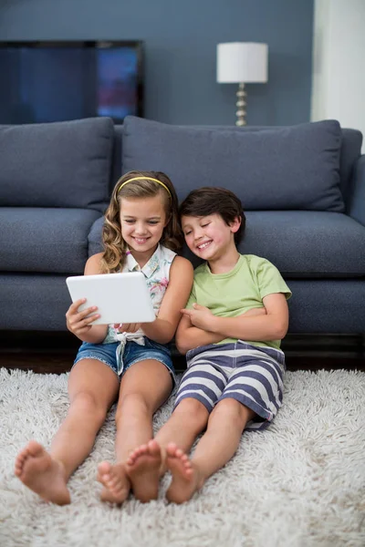 Fratelli che utilizzano tablet digitale in salotto — Foto Stock