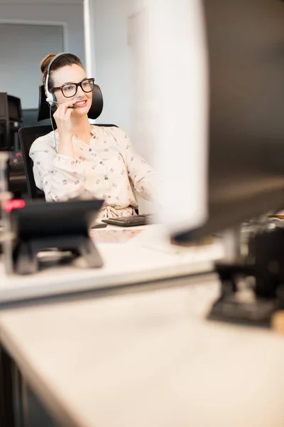 Empresária falando no fone de ouvido no escritório — Fotografia de Stock