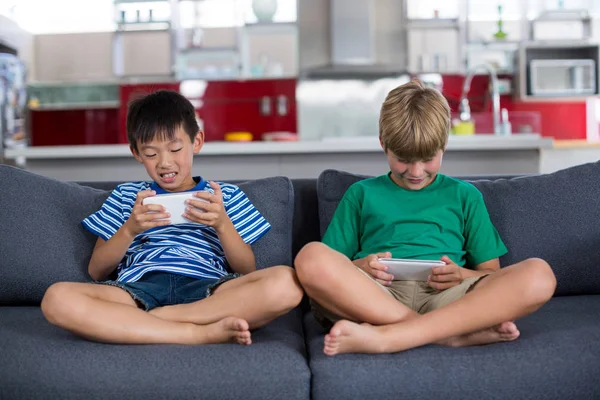 Geschwister nutzen Handy im Wohnzimmer — Stockfoto
