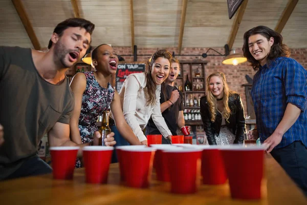 Amigos jugando cerveza pong juego en el bar — Foto de Stock