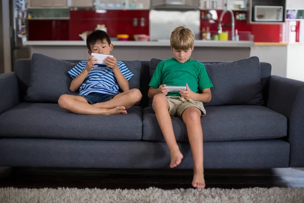 Geschwister nutzen Handy im Wohnzimmer — Stockfoto