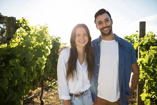Smiling couple standing at vineyard — Stock Photo, Image