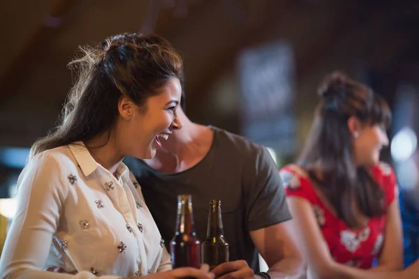 Женщина смотрит в сторону, держа бутылку пива — стоковое фото