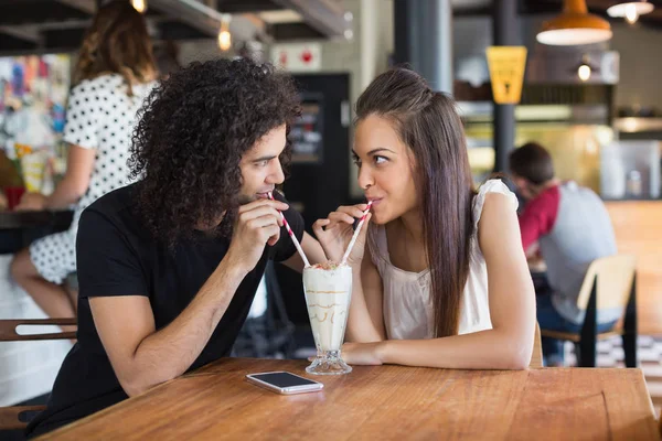 Couple looking at each other while having drink — Stock Photo, Image