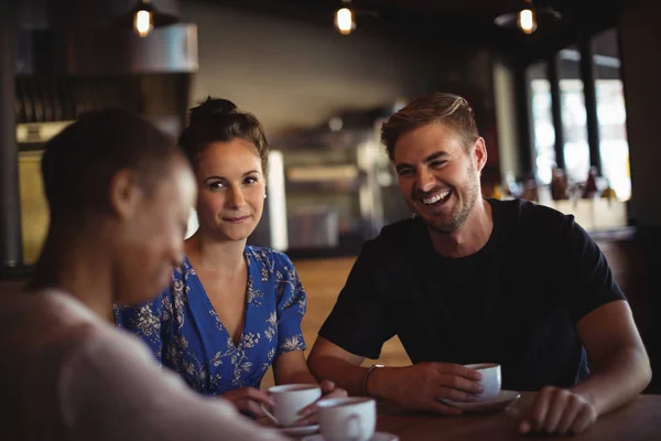 Friends interacting while having coffee — Stock Photo, Image