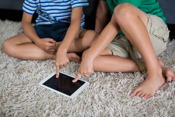 Irmãos usando tablet digital na sala de estar — Fotografia de Stock