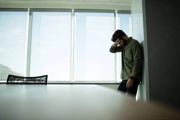 Depressed businessman standing by window — Stock Photo, Image