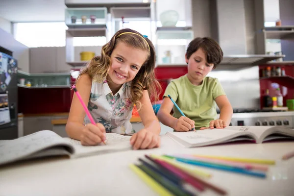 Broers en zussen huiswerk in de keuken — Stockfoto