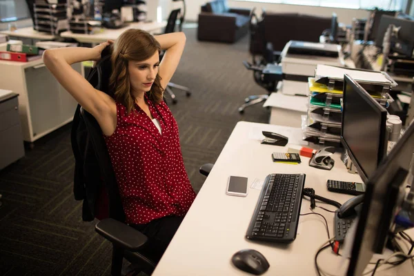 Forretningskvinne som slapper av ved skrivebordet – stockfoto