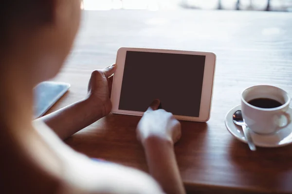 Femme utilisant un comprimé tout en prenant un café — Photo