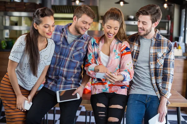 Friends laughing while watching mobile phone — Stock Photo, Image