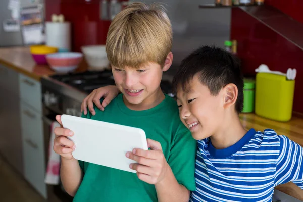 Geschwister nutzen digitales Tablet in Küche — Stockfoto