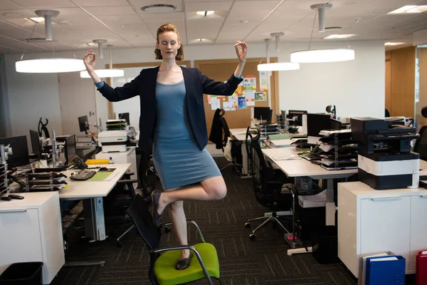 Businesswoman practicing yoga at office — Stock Photo, Image