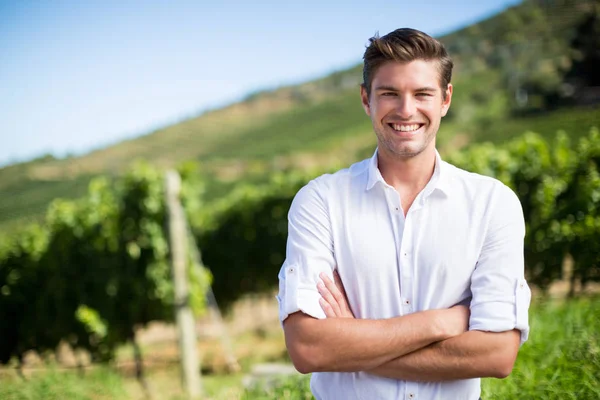 Людина з обіймами, що стоять на винограднику — стокове фото