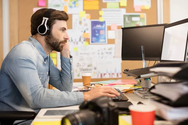 Affärsman som bär hörlurar medan du arbetar — Stockfoto