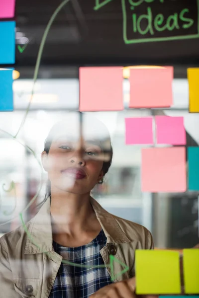 Male and female executives looking at sticky notes — Stock Photo, Image