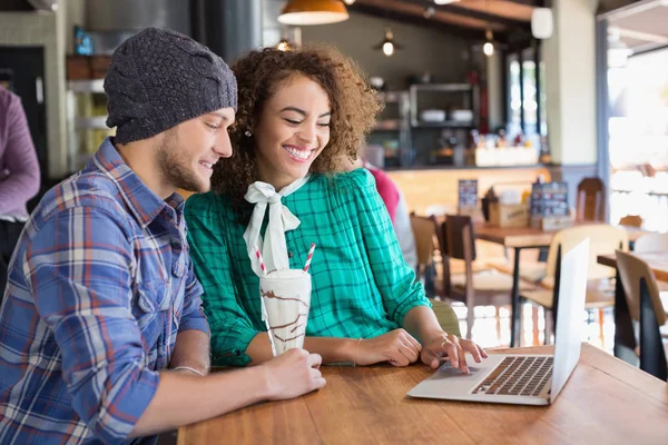 Friends using laptop at table in restaurant — Stock Photo, Image