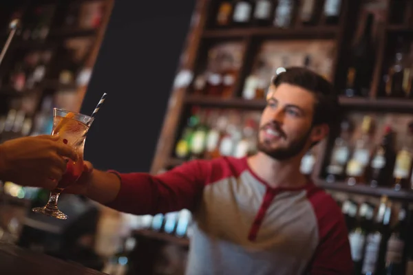 Bar anbud att ge cocktail glas till kund — Stockfoto
