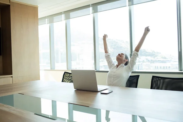 Empresária alegre sentada na sala de conferências — Fotografia de Stock