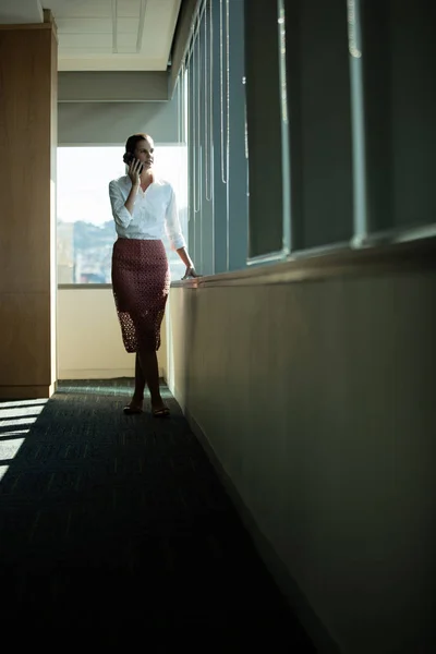 Geschäftsfrau telefoniert am Fenster — Stockfoto